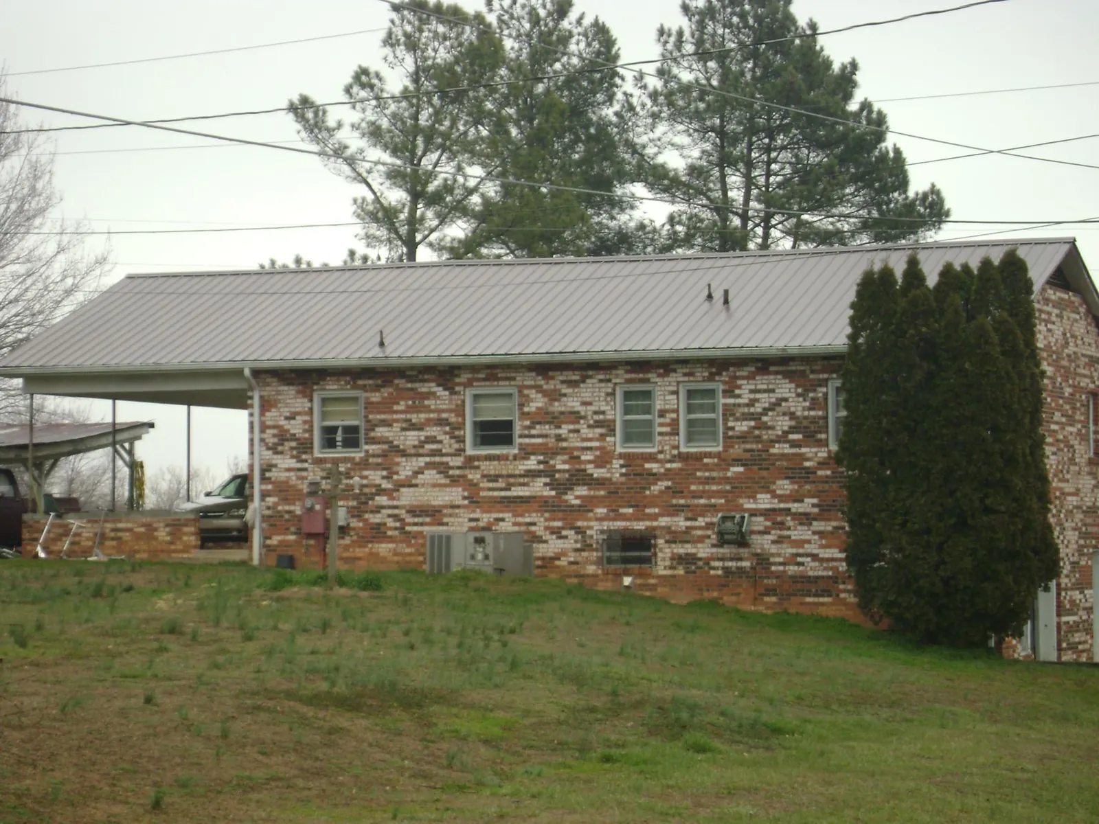 Gray metal roof on a brick split level home with a carport in Tuppers Plains